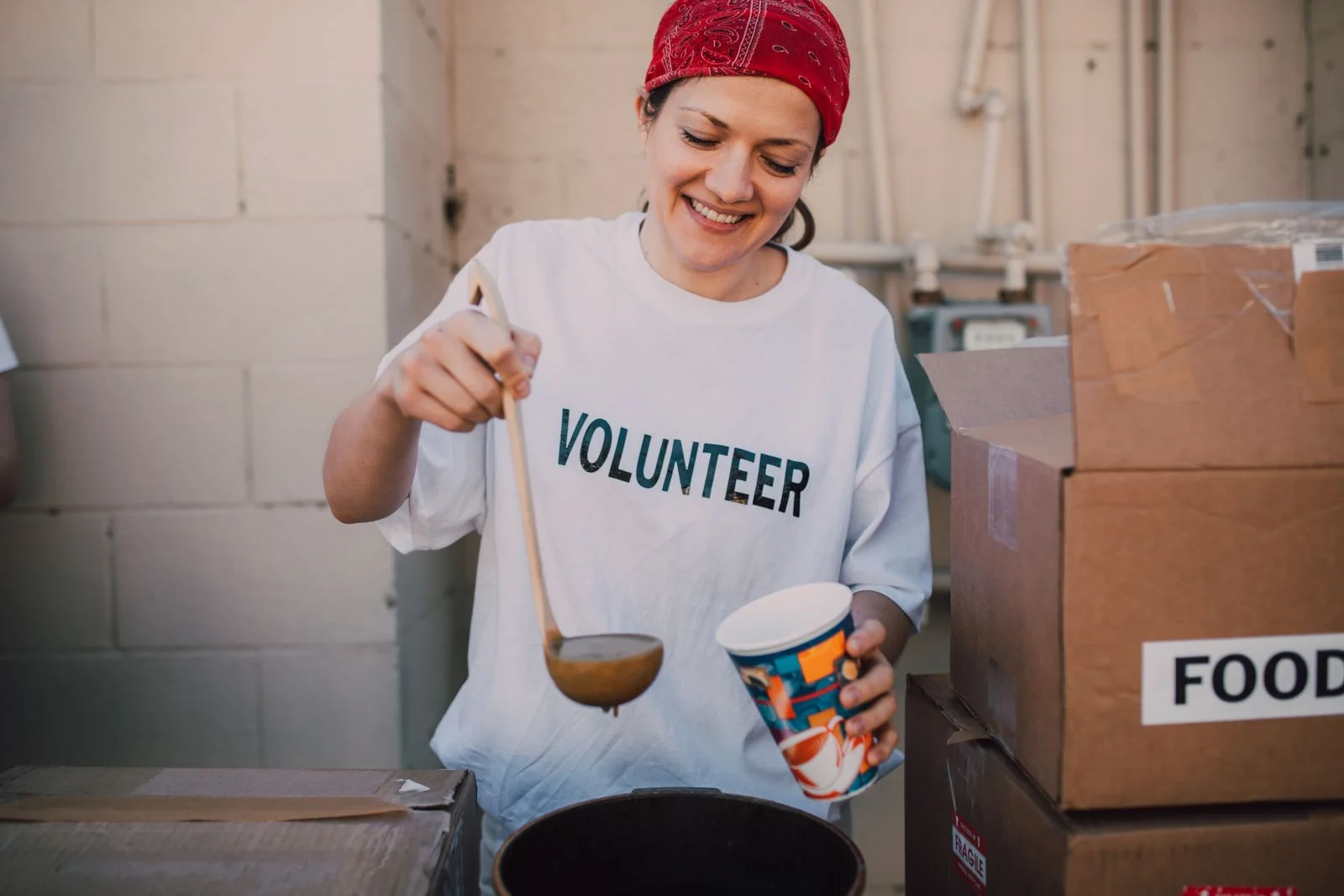 A volunteer preparing food at a community table